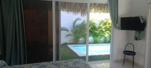 1 dormitorio con ventana y vistas a la piscina en Zodiaco in Las Terrenas, en Las Terrenas