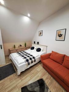 a bedroom with a bed and a red couch at Luna Apartman in Eger