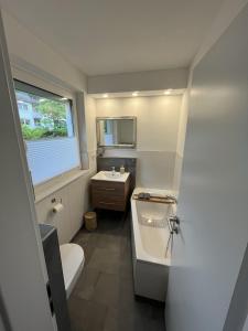 ein Badezimmer mit einer Badewanne, einem Waschbecken und einem WC in der Unterkunft Ferienhaus Hildchen an der Osterheide in Schneverdingen