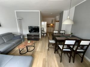een woonkamer met een bank en een eettafel bij Ferienhaus Hildchen an der Osterheide in Schneverdingen