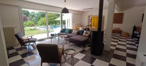 - un salon avec un canapé et une cheminée dans l'établissement Magnifique villa 5 etoiles avec piscine privee parc 2 ha, à La Limouzinière