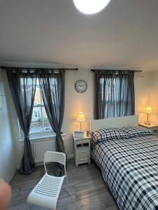 een slaapkamer met 2 bedden en een klok aan de muur bij Guest and Rest 7 in Londen