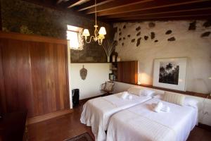 1 dormitorio con 2 camas y lámpara de araña en Casa rural cerca de la costa de La Laguna en La Laguna