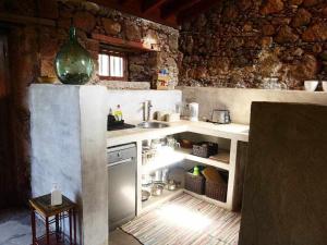 Una pequeña cocina con fregadero y estufa. en Casa rural cerca de la costa de La Laguna, en La Laguna
