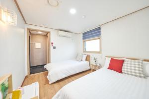 um pequeno quarto com uma cama e uma janela em K'STAY Sinchon em Seul