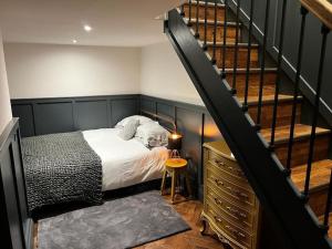 a bedroom with a bed next to a staircase at Unique Victorian stable conversion Halifax in Halifax