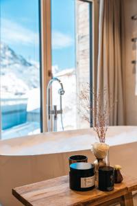 a table with two candles and a sink and a window at Hotel Maiensee in Sankt Christoph am Arlberg