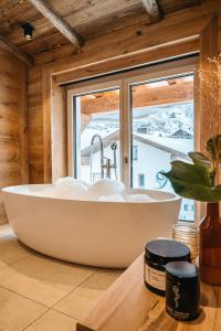 a bath tub in a room with a window at Hotel Maiensee in Sankt Christoph am Arlberg