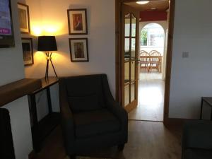 Comfy Cottage في باليمينا: غرفة معيشة فيها كرسي وتلفزيون