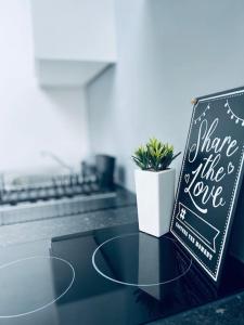 um sinal de quadro negro sentado num balcão com uma planta em Contemporary studio apartment em Pemberton