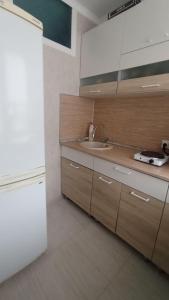 uma cozinha com um lavatório e um frigorífico branco em 2-комнатная квартира Ген.Дбар/Лакоба em Sukhumi