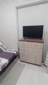 um quarto com uma cómoda e uma televisão de ecrã plano em 2-комнатная квартира Ген.Дбар/Лакоба em Sukhumi