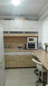 een keuken met houten kasten en een fornuis met oven bij 2-комнатная квартира Ген.Дбар/Лакоба in Sukhumi