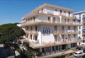 um grande edifício branco com um cartaz em Hotel Midi em Lido di Jesolo