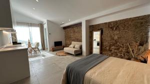 - une chambre avec un lit et un mur en pierre dans l'établissement ART HOMES LAVADERO, à Valence
