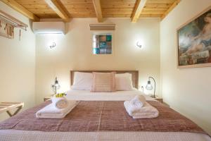 a bedroom with a bed with two towels on it at Avocado Villa Iason in Chania