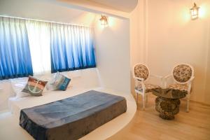 een slaapkamer met een bed en 2 stoelen en een raam bij The Voyage - Cafe Hostel CoWork in Pune