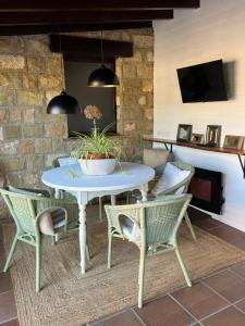 een patio met een tafel en stoelen en een televisie bij Posada La Vieja Escuela in La Revilla