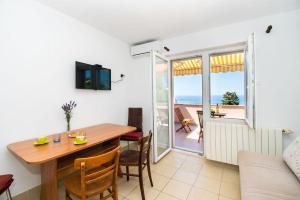 une salle à manger avec une table et une vue sur l'océan dans l'établissement Apartments Igor, à Jakišnica