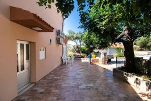 une passerelle à l'extérieur d'une maison avec un arbre dans l'établissement Apartments Igor, à Jakišnica