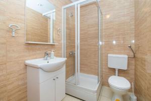 une salle de bain avec douche, lavabo et toilettes dans l'établissement Apartments Igor, à Jakišnica 39 autres photos