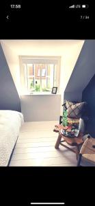 een slaapkamer met een bed, een tafel en een raam bij Danish villa with a lovely garden & close to Copenhagen in Gentofte