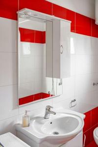 een badkamer met een witte wastafel en een spiegel bij Apartment Plava Beach in Vodice