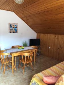 a dining room with a table and chairs and a television at Apartments Ruza in Ražanj