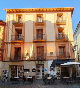a large building with tables in front of it at Hotel Acebo Plaza Mayor in Jaca