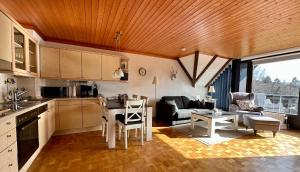 een keuken en woonkamer met een bank en een tafel bij Ferienwohnung Weitblick am Kurpark in Braunlage +15 foto's