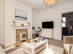 a living room with a fireplace and a tv at Oystercatcher Bay in Weymouth