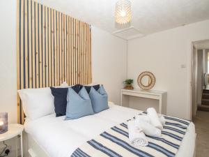 a bedroom with a bed with blue and white pillows at Oystercatcher Bay in Weymouth