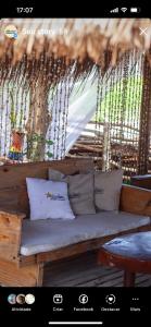 - un canapé avec des oreillers installés sur une terrasse couverte dans l'établissement Pousada e Restaurante Stella Maris, à São José da Coroa Grande