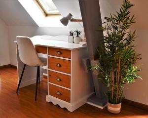 a desk with a chair and a lamp and a plant at Cœur des chevaux in Deauville