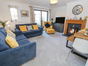 sala de estar con sofás azules y chimenea en Tennyson View, en Totland