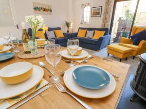 una mesa de comedor con platos y copas de vino. en Tennyson View, en Totland