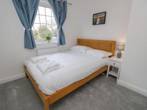 sypialnia z dużym łóżkiem i oknem w obiekcie Tennyson View w mieście Totland