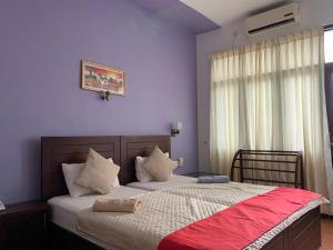 a bedroom with a large bed with a red blanket at Subhas Tourist Hotel in Jaffna