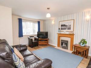 a living room with a leather couch and a fireplace at Chandler's View in Whitby