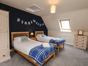 a bedroom with two beds and a black wall at Chandler's View in Whitby
