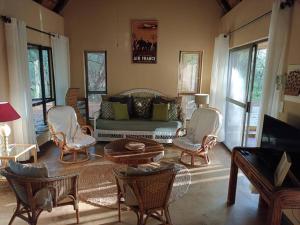 a living room with a couch and chairs and a table at Hoedspruit Bush Cottage in Hoedspruit