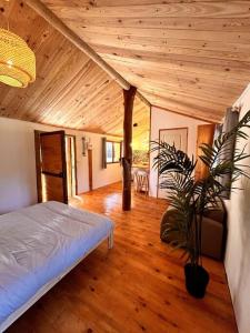 a bedroom with a bed and a wooden ceiling at Chalet Privé Cosy in Malaussène