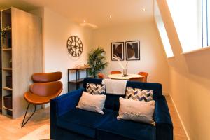 a living room with a blue couch and a table at Furness House by Pay As U Stay in Redhill