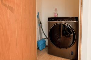 a washing machine in a room with a broom at Furness House by Pay As U Stay in Redhill