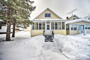 a house with snow in front of it at Aurora Outdoorsy Getaway with Deck and Grill! in Biwabik