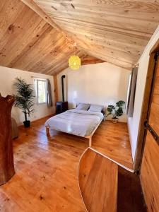 a bedroom with a bed and a wooden ceiling at Chalet Privé Cosy in Malaussène