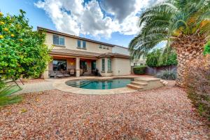 a house with a swimming pool and a palm tree at Updated Gilbert Home with Pool and Community Amenities in Queen Creek