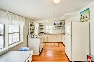 cocina con electrodomésticos blancos y nevera blanca en Charming Waterfront Cottage with Private Dock!, en South Haven