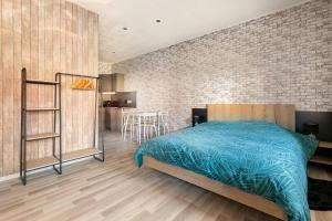 a bedroom with a bed and a brick wall at Le studio in Lembach