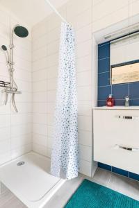 a bathroom with a shower curtain and a sink at Le studio in Lembach